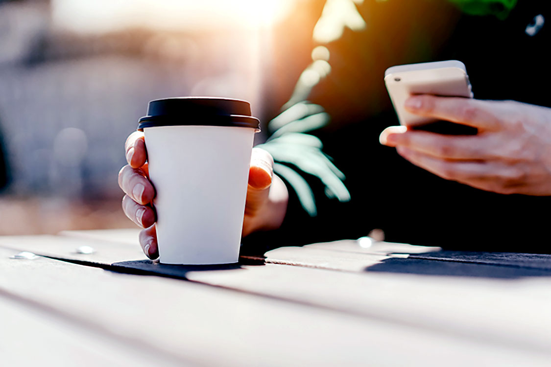 man drinking hot coffee outside using locelli app